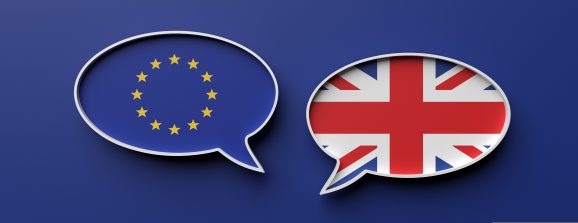 UK and EU Brexit concept - English and European Union flag speech bubbles against blue background