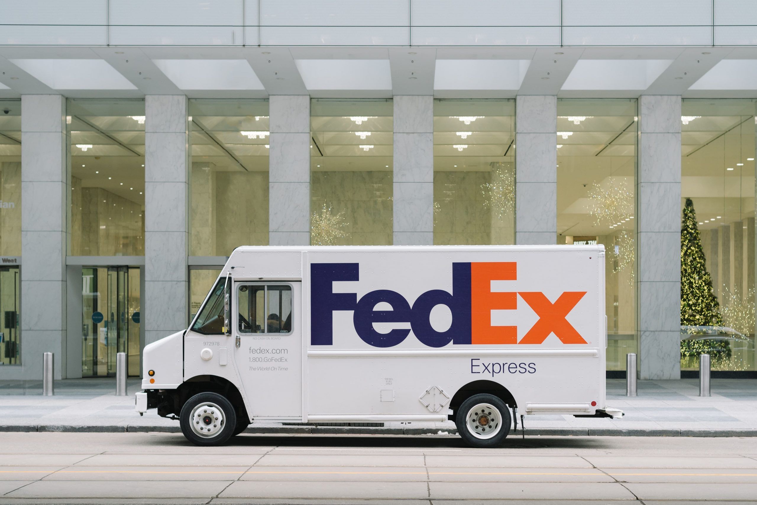 White FedEx van in front of a glass building