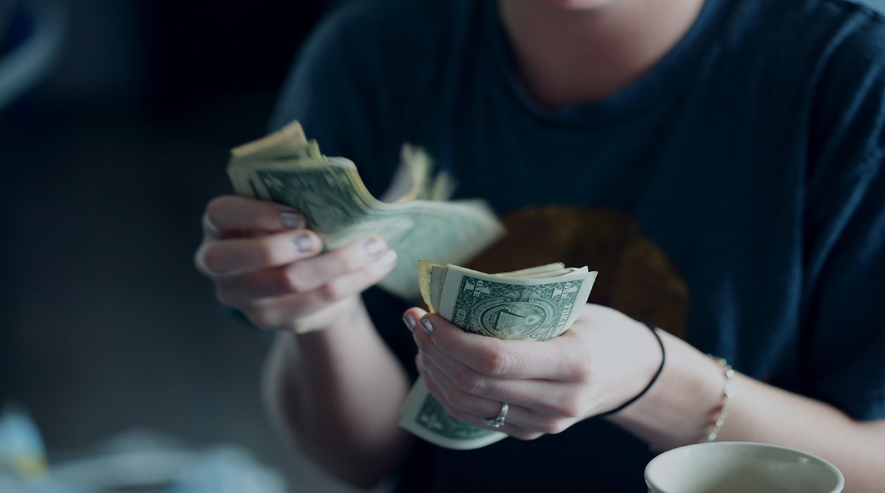 Person counting a handful of money
